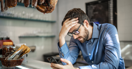 frustrated man looking at phone